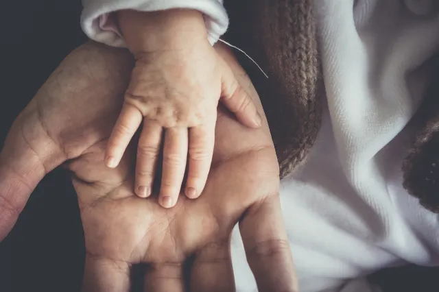 mano di un bambino nella mano di un adulto