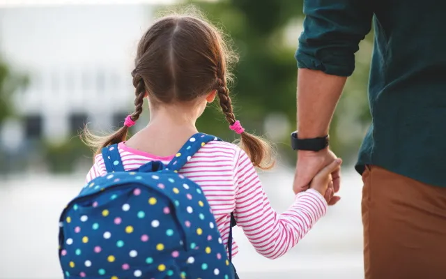 immagine di un padre che accompagna la figlia a scuola per evocare il tema dell'adozione e dell'affido