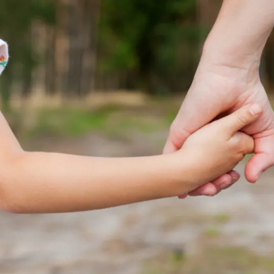 genitore che tiene per mano la figlia