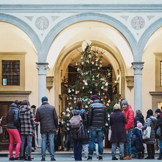 genitori e bambini davanti all'albero di Natale nel Cortile degli Uomini dell'Istituto degli Innocenti