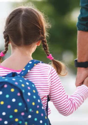 immagine di un padre che accompagna la figlia a scuola per evocare il tema dell'adozione e dell'affido